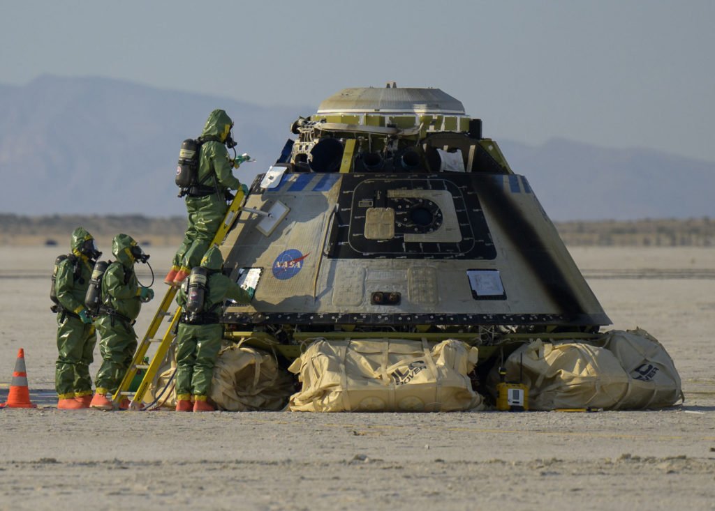 Habillées de combinaisons de protection, les équipes au sol vérifient les éventuelles émanations dangereuses sur la capsule Starliner OFT-2
