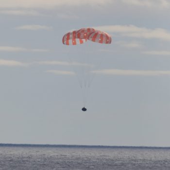 La capsule Orion descend vers l'océan Pacifique sous ses 3 parachutes